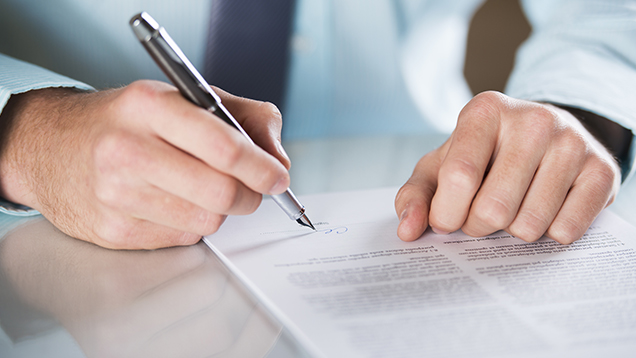 Mannen skriver under kontraktet.