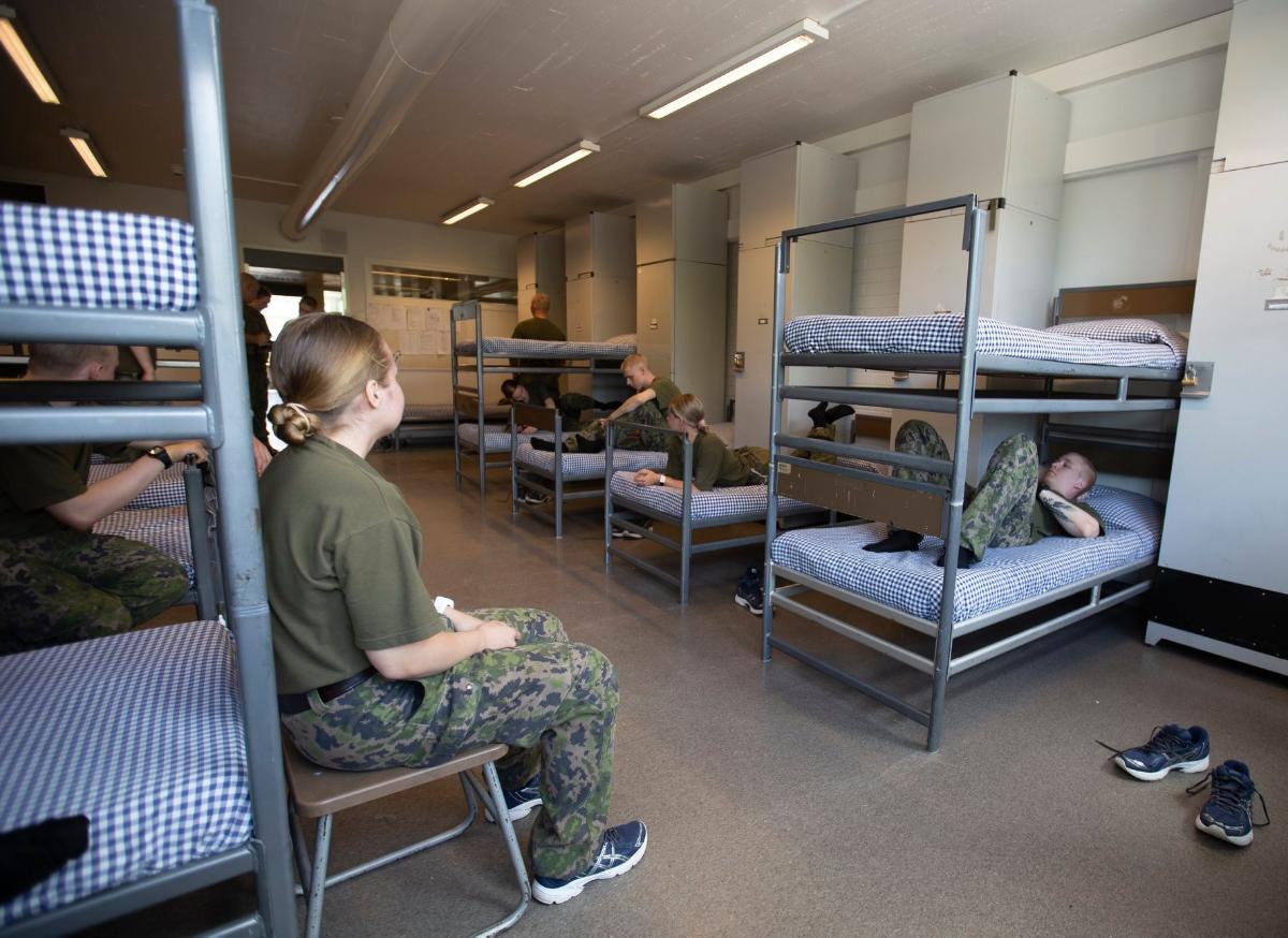 Varusmiehiä marssii ulkona maastopuvuissa